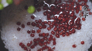 將炒好的食材和大米、紅豆一起放進(jìn)電飯鍋煮。