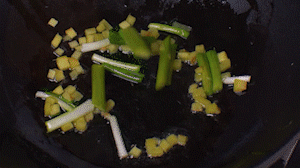 鍋中熱油，依次下姜粒、蔥段、蘆筍炒香。