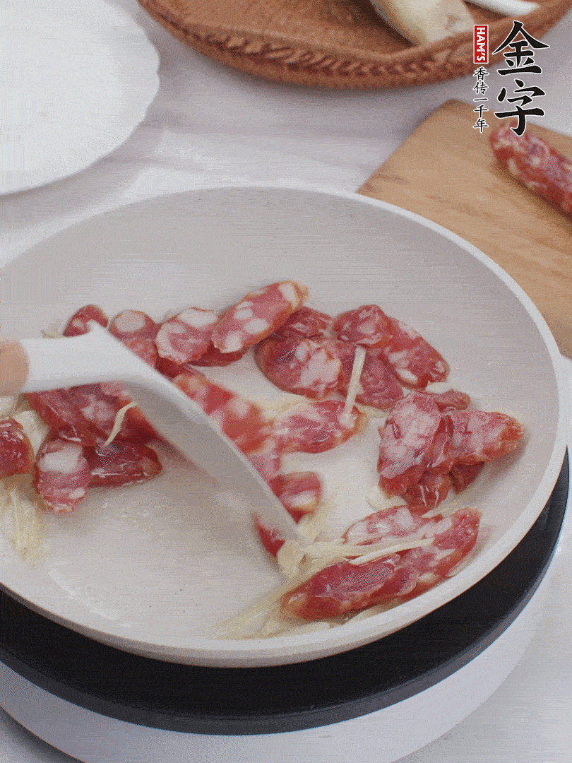 油溫3成熱時，下姜絲、蒜片、香腸炒出油脂。