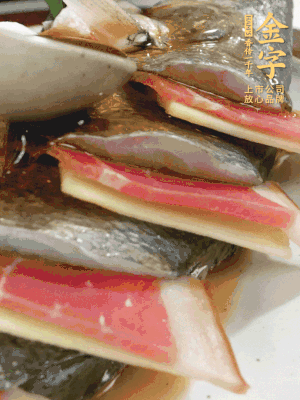 魚肚中塞蔥結(jié)、火腿片，魚身上碼放姜片、火腿片，倒入混合的料汁。